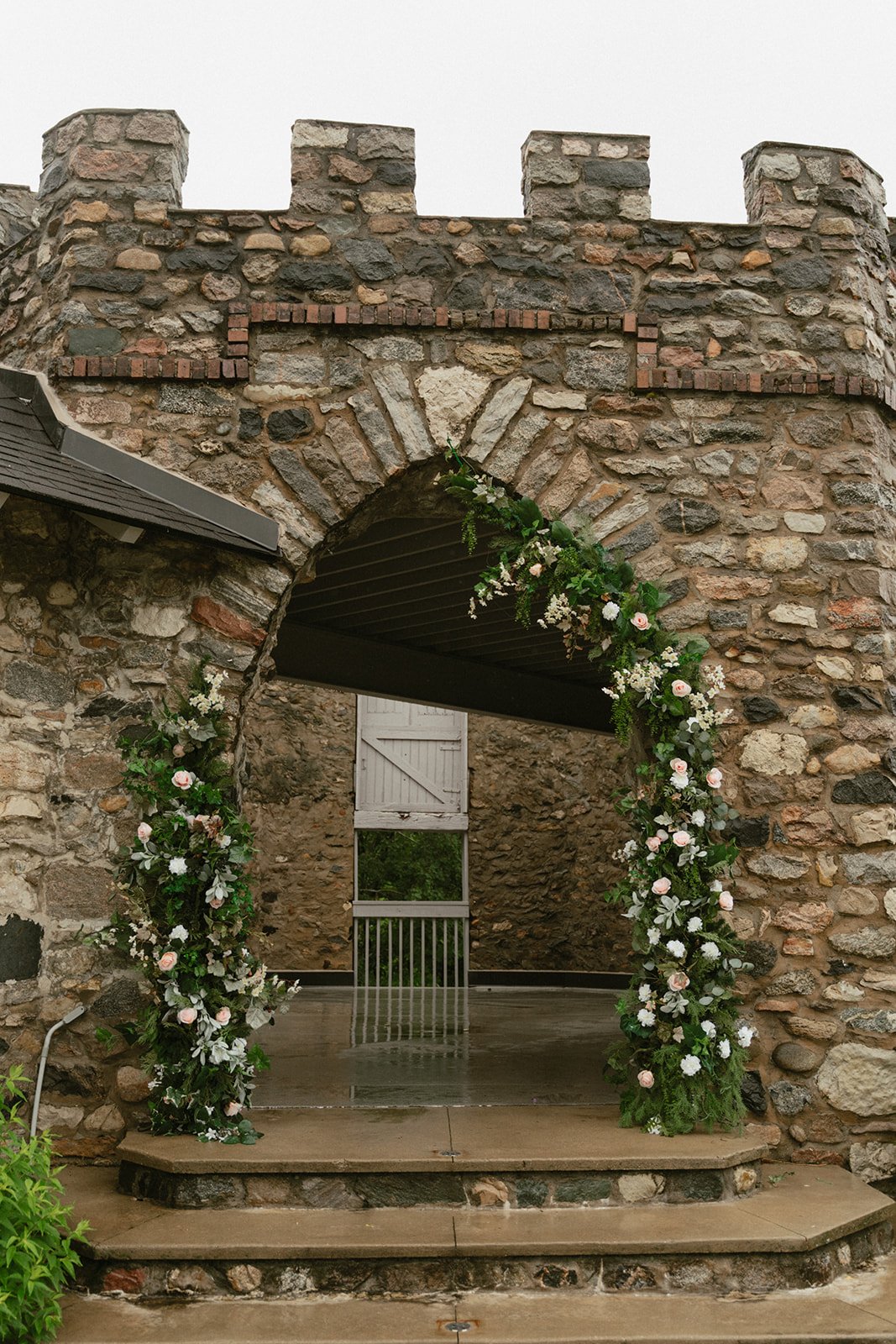 Greenery archway framing stone castle ruins